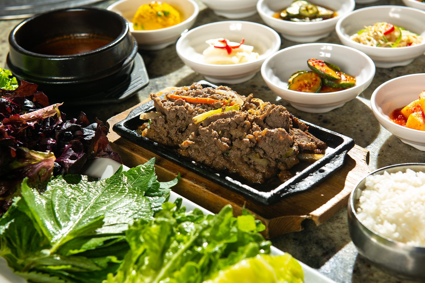 Sizzling bulgogi with ssam lettuce, perilla leaves and banchan